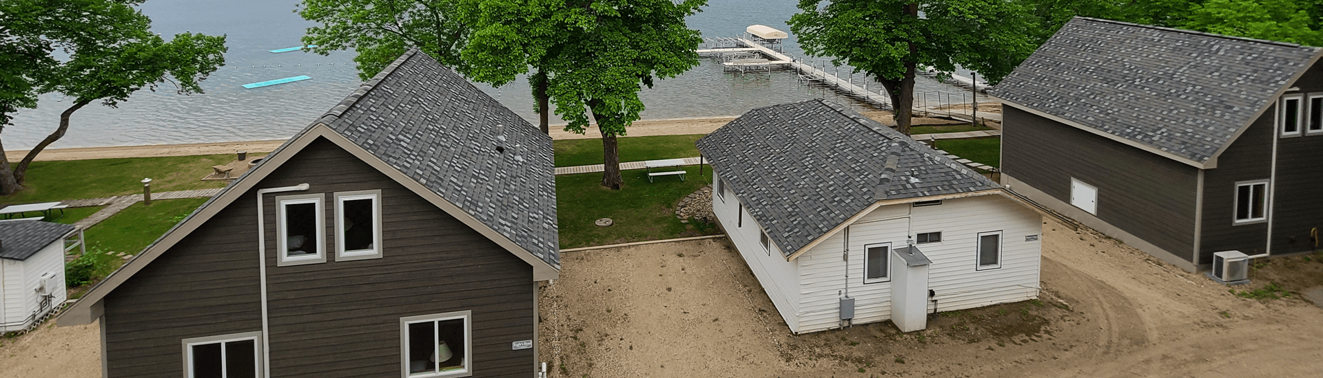 Aerial view of Multiple cabins near lake with sandy lake shore